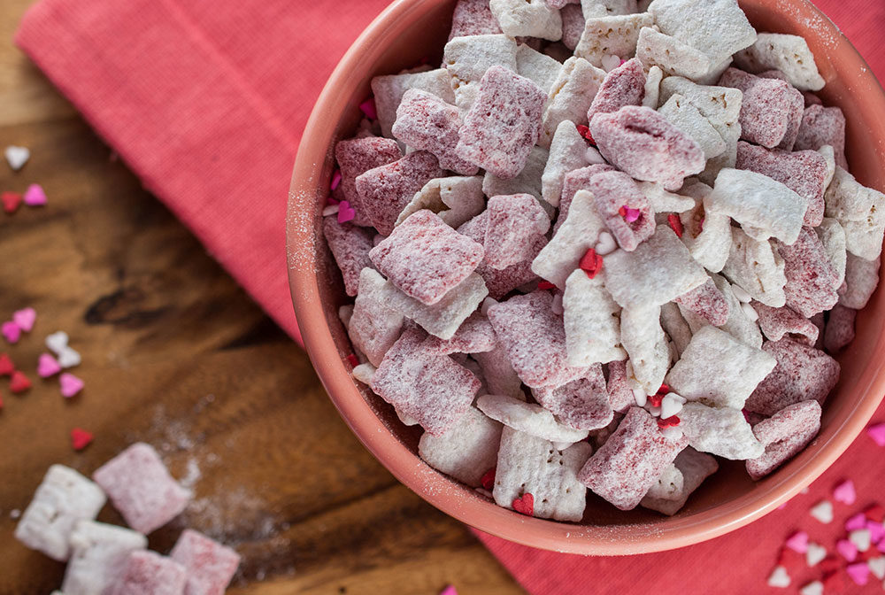 A close-up of Muddy Buddies, coated in powdered sugar and ready to enjoy